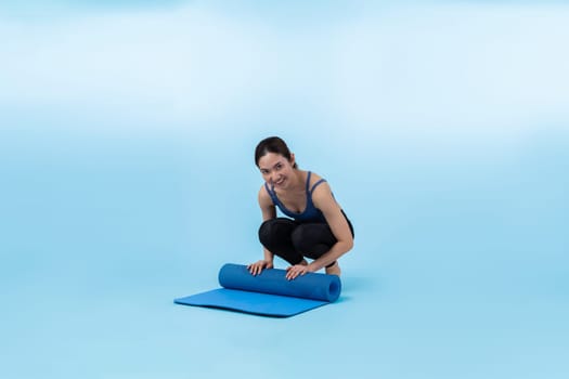 Young attractive asian woman portrait in sportswear with exercising mat. Healthy exercise and workout routine lifestyle concept. Studio shot isolated background. Vigorous