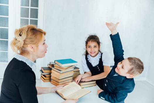 Teacher at lesson at school with children and books