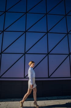 fashionable woman near glass wall showcase