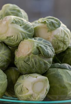 Close up of Fresh raw organic Green brussel sprouts vegetable on Wooden cutting board with Natural sunlight. Uncooked brussels sprouts, Space for text, Selective focus.