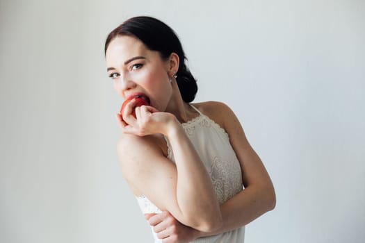 woman biting an apple in a bright room