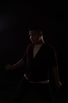 A man dancing in the dark in a studio music