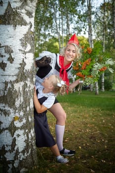 Young and adult schoolgirl on September 1, mother and daughter having fun and joy. Generations of schoolchildren of USSR and Russia. Female pioneer in red tie and October girl in modern uniform