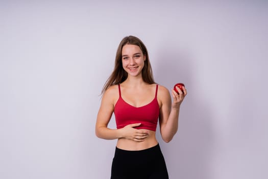 Cropped of sporty female with well fit body holding an apple, healthy food and fit body concept