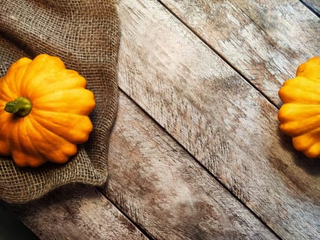 Yellow pattison on wooden boards of table and on fabric is sackcloth or burlap. Healthy Delicious Beautiful Vegetable in autumn. Abstract Background, texture, frame, place for text and copy space