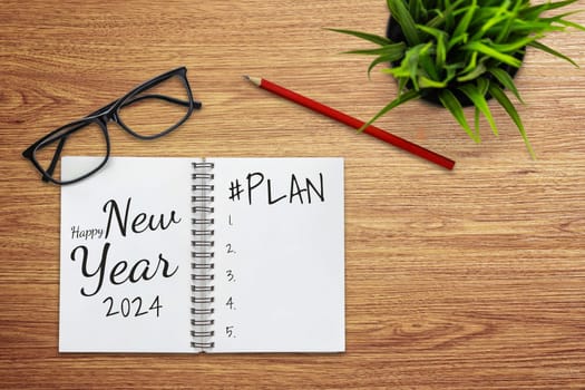 2024 Happy New Year Resolution Goal List and Plans Setting - Business office desk with notebook written about plan listing of new year goals and resolutions setting. Change and bliss concept.