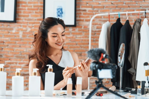 Woman influencer shoot live streaming vlog video review makeup uttermost social media or blog. Happy young girl with cosmetics studio lighting for marketing recording session broadcasting online.