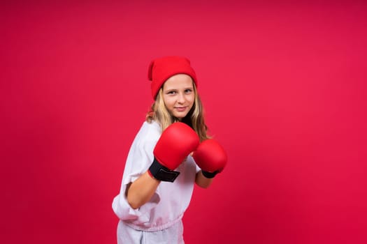 Little girl wearing red boxing gloves, studio shot, sport conception