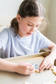 A heartwarming scene of a little girl carefully writing 'Sorry' on sugar cookies with food coloring, the cookies beautifully flooded with white royal icing.