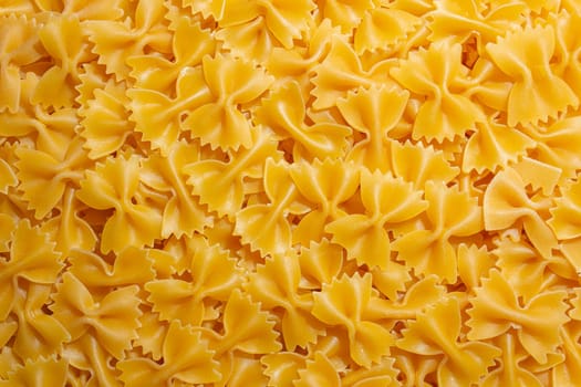 Uncooked Farfalle Pasta: A Culinary Canvas of Bow-Tie Macaroni, Creating a Lively and Textured Background for Gourmet Cooking. Dry Pasta. Raw Macaroni - Top View, Flat Lay
