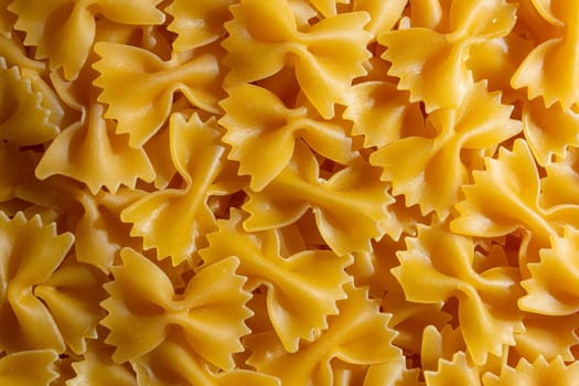 Uncooked Farfalle Pasta: A Culinary Canvas of Bow-Tie Macaroni, Creating a Lively and Textured Background for Gourmet Cooking. Dry Pasta. Raw Macaroni - Top View, Flat Lay