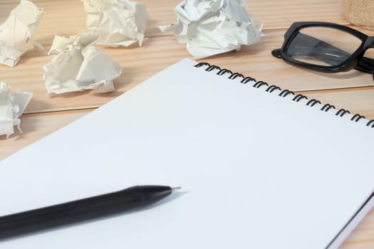 Notepad with trash paper background on wooden desk. Copy space.