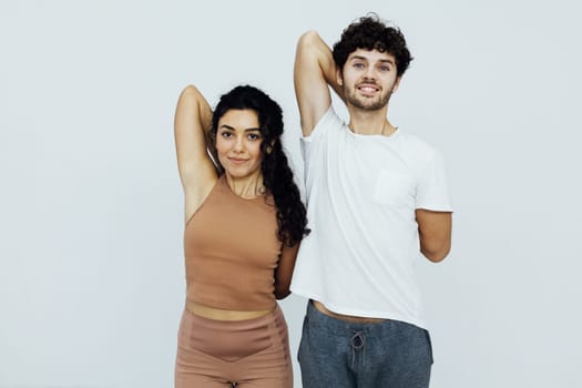 Yoga group concept. Young couple meditating together, sitting back to back on windows background