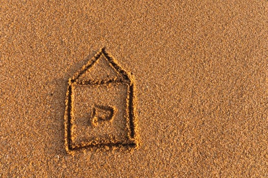 The house is drawn on the sand. drawing of a house on the beach, safety and relaxation concept.