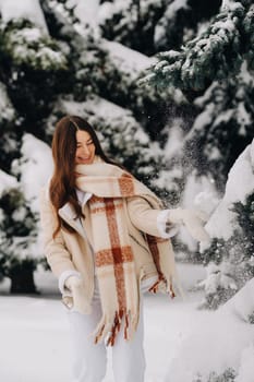 Portrait of a girl with long hair in mittens in a winter forest . Snowy winter.