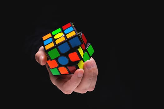Rubik's cube in the hands of a girl close-up. Young woman trains her brain and develops thinking.