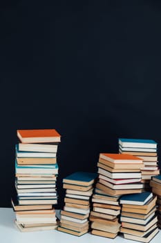 Lots of stacks of educational books on black background library