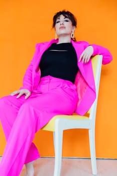 Portrait of a beautiful woman in a purple business suit on a chair