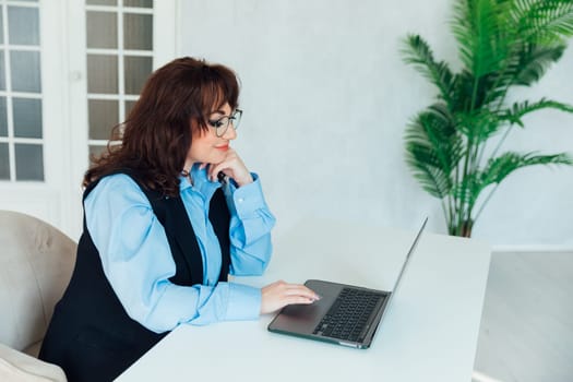 Portrait of Young Successful Caucasian Businesswoman Sitting at Desk Working on Laptop Computer in City Office. Ambitious Corporate Manager Plan Investment Strategy for e-Commerce Project.