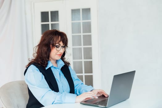 Portrait of Young Successful Caucasian Businesswoman Sitting at Desk Working on Laptop Computer in City Office. Ambitious Corporate Manager Plan Investment Strategy for e-Commerce Project.