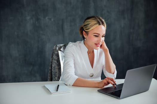 Stylish Female Working on Laptop Computer in a Company Office in the Evening. Young Manager Browsing Internet, Shopping Online and Reading Social Media Posts from Friends and Colleagues.