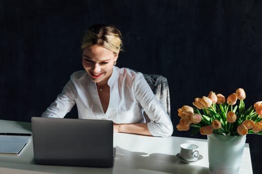 Stylish Female Working on Laptop Computer in a Company Office in the Evening. Young Manager Browsing Internet, Shopping Online and Reading Social Media Posts from Friends and Colleagues.