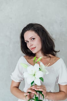 Beautiful brunette woman in white summer dress with beautiful archidea flower