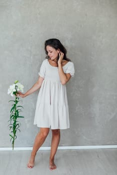 Beautiful brunette woman in white summer dress with beautiful archidea flower