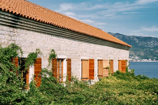 St. Mary Castle with open wooden shutters surrounded by greenery. Budva, Montenegro. High quality photo