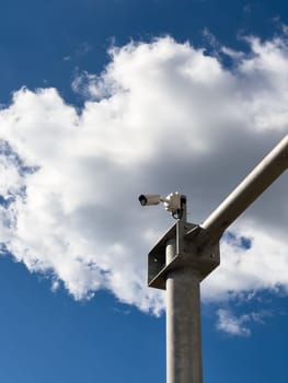 Road surveillance camera on a pole against a cloudy sky. High quality photo