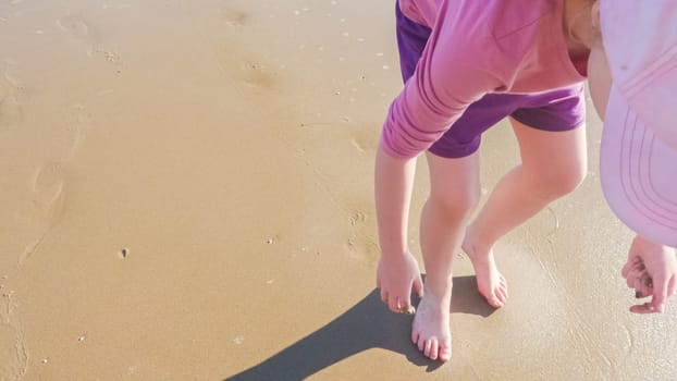 A little girl joyfully plays on the vast, empty sands of El Capitan State Beach in California during winter.