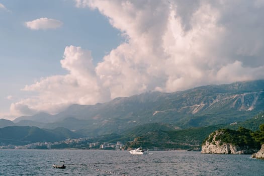 Motor yacht sails on the sea along the mountain coast. High quality photo