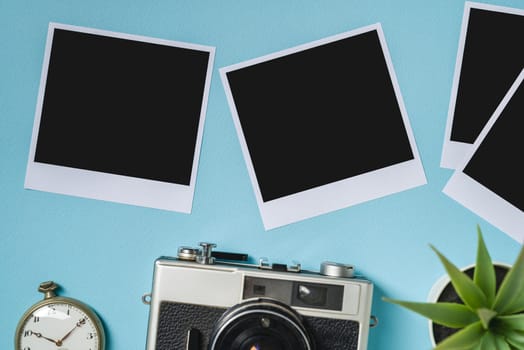 Vintage photo camera and empty photo frames on blue background. Travel moment concept