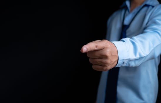 Employee makes a forward pointing gesture on a dark background.