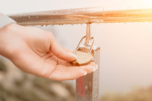 Metal padlocks covered with rust, hanging by the lovers on iron railings on the pier