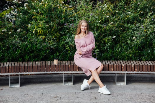 slender blonde woman in pink clothes on a walk outdoors