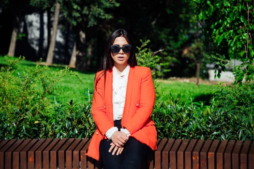 Beautiful fashionable woman in red business suit outdoors