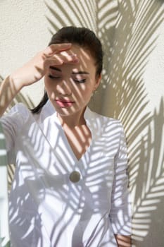 fashionable brunette woman and shadow from leaves in the sun