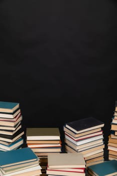 Many stacks of books to study in the university library on a background