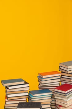 Many stacks of books to study in the university library on a background