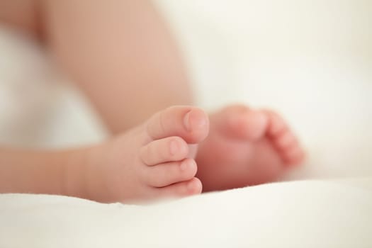 Child, newborn and feet or toes closeup or infant development, safety care or growth support. Baby, foot and soft skin asleep for healthy birth on blanket love or tiny legs or wellness, youth in home.