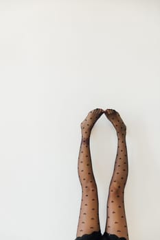 slender female legs in black stockings pantyhose