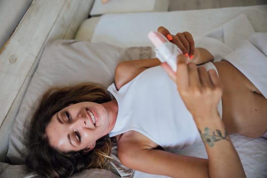 woman in pajamas with gift in bedroom on bed