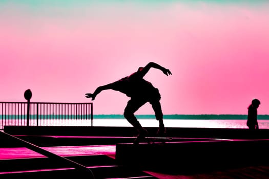 Unrecognizable teenage boy silhouette showing high jump tricks on scooter against orange sunsetwarm sky at skatepark. Sport, extreme, freestyle, outdoor activity concept