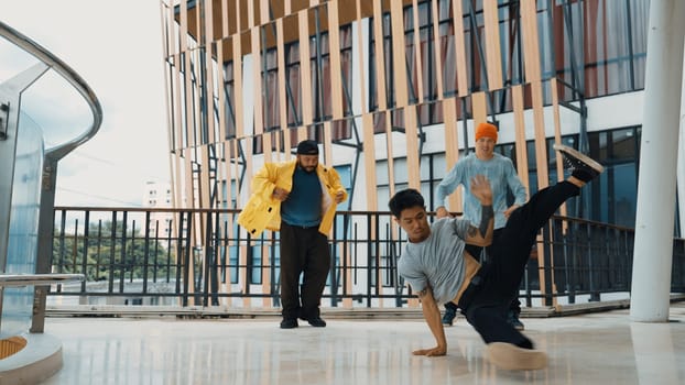 Hip hop team dance break dance while multicultural friend surrounded and clapping hands to cheer or encourage his friend to dance. Active and energetic street dance. Outdoor sport 2024. Endeavor.