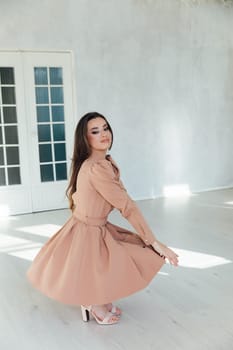 woman in dress posing in bright room near door