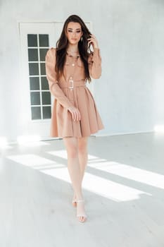 woman in dress posing in bright room near door