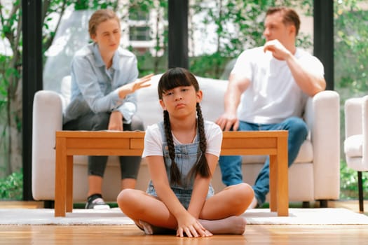 Stressed and unhappy young girl crying and trapped in middle of tension by her parent argument in living room. Unhealthy domestic lifestyle and traumatic childhood develop to depression. Synchronos