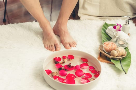 Woman indulges in blissful foot massage at luxurious spa salon while masseur give reflexology therapy in gentle day light ambiance resort or hotel foot spa. Quiescent