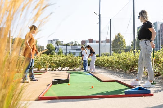 White golf ball rolling down golf hole on putting green with evening golf course backdrop . High quality photo